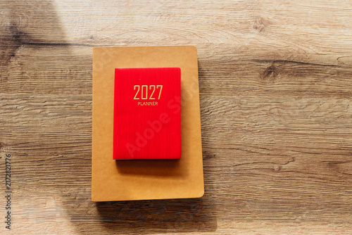 Red 2027 planner notebook on wooden background