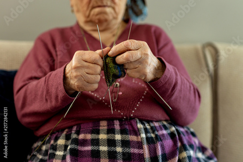 Canvas Print Older woman enjoying her knitting hobby at home