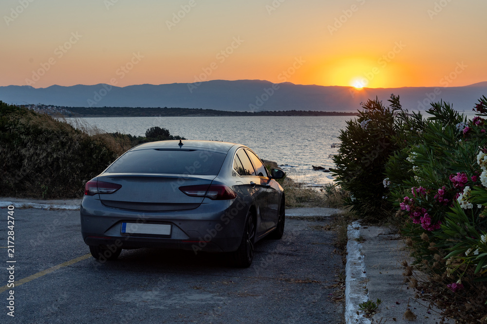 Obraz premium Gray sedan parked at scenic coastal sunset overlook