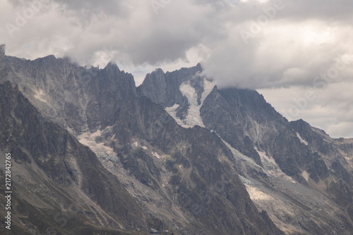 Alpine mountain range with glaciers and dramatic clouds