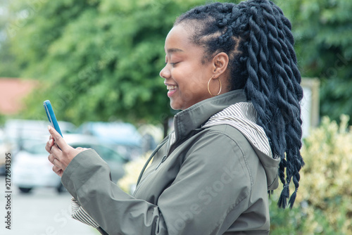 black woman with phone on the street