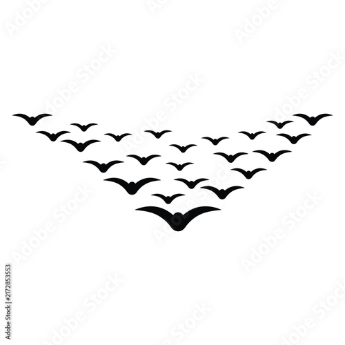 A flock of black birds flying in a V-shaped formation isolated on a white background.