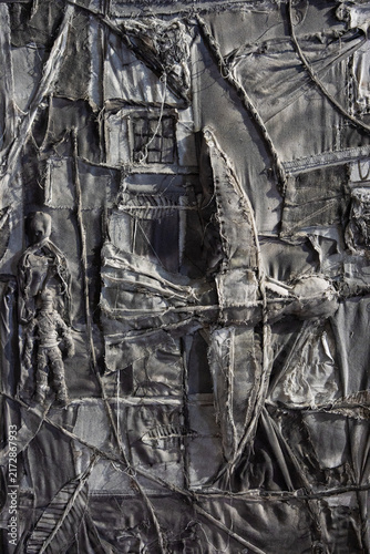 Intricate grey textile art collage with abstract figures and textures
