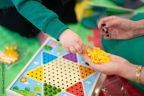 Konstfotografi High-angle view of children and an adult playing a star-shaped peg game