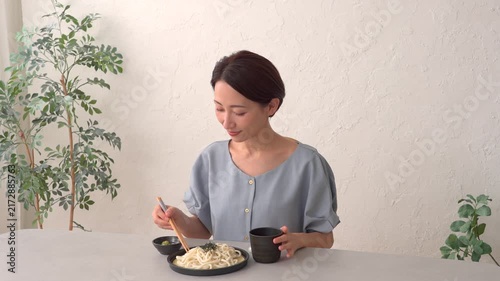 リビングでざるうどんを食べる女性