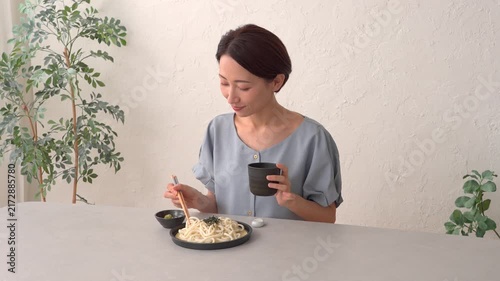 リビングでざるうどんを食べる女性