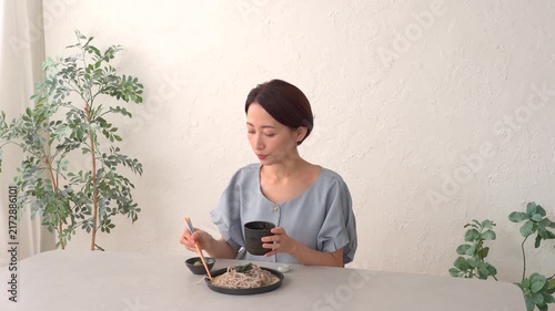 リビングでざるそばを食べる女性