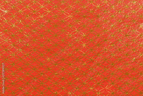 Motivo geometrico dorato su sfondo rosso con cerchi intrecciati. Texture decorativa elegante, ideale per packaging, design festivo, grafica ornamentale e progetti creativi.