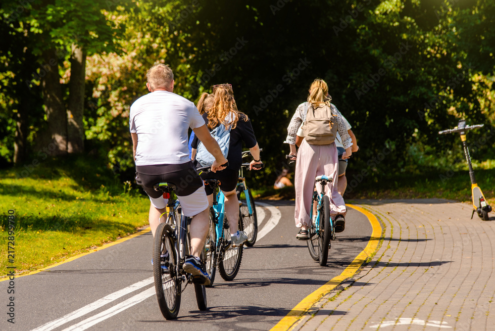 Fototapeta premium Cyclists ride on the bike path in the city Park 