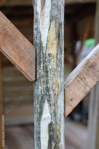 Close-up shot of a wooden pillar construction with diagonal support beam joint for structural support.