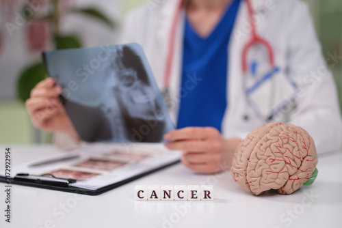 Fotografie Doctor oncologist looks at xray of patient with brain cancer closeup