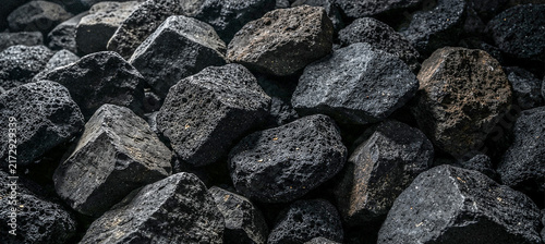 Fotografie A close-up view of various black rocks and stones, showcasing their textured surfaces and irregular shapes