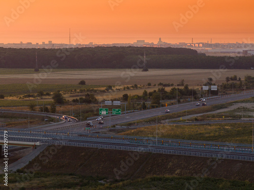 Foto Scenic aerial view of Bucharest A0 highway ring road at golden sunrise with modern infrastructure, interchange junction, morning vehicle traffic and skyline