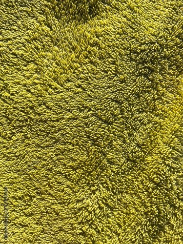 Close-up texture of a soft green terry towel fabric, abstract fluffy cotton textile background