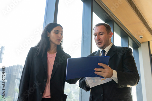 Foto Businessman and businesswoman having a heated argument in a bright office