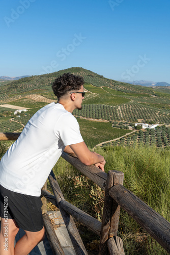 Quadro su tela Man in sunglasses enjoying the rural view from a hilltop, contemplating the sere