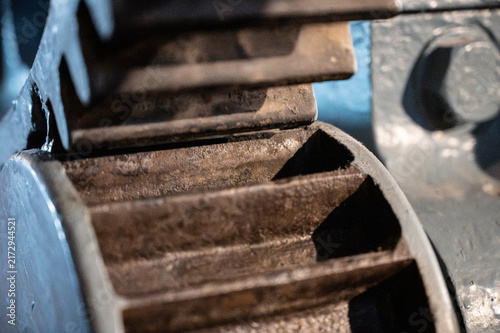 Close-up of old heavy industrial spur gears meshing, showing the contact surface and mechanical structure of vintage machinery