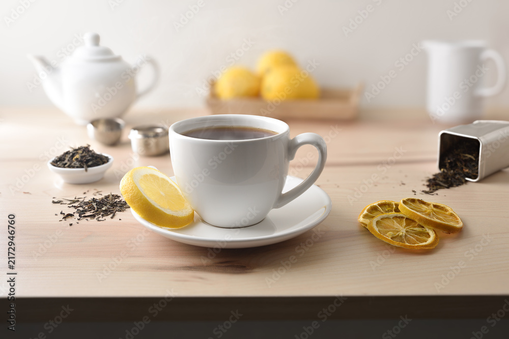 Fototapeta premium Hot tea on table with lemon tea and kitchen items