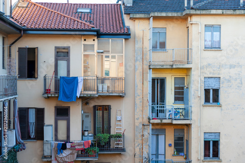Balconi di edifici residenziali con panni stesi, oggetti domestici e facciate vissute. Scena urbana autentica che mostra la quotidianità e l’architettura di palazzi storici.