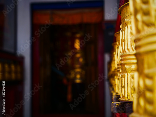 Obraz na płótnie Golden prayer wheels lined up inside a traditional Buddhist temple in the Khumbu