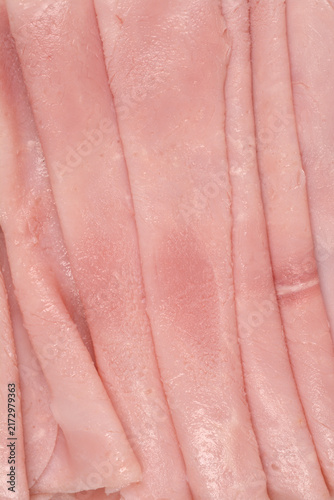 Full frame macro view showing the rough texture and fine details of overlapping thin slices of pink cooked deli ham