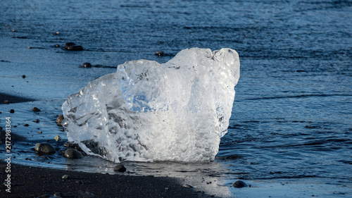 Cuadro en lienzo Melting ice from Vatnajokull Glacier drifts onto the black sand shore of Diamond Beach, Iceland, showing ancient glacial ice and the effects of ongoing climate change