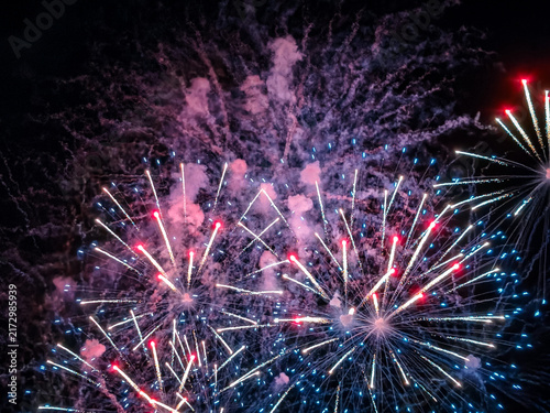 Konstfotografi Fuegos artificiales dorados y destellos rojos iluminan el cielo nocturno en una espectacular exhibición pirotécnica de celebración