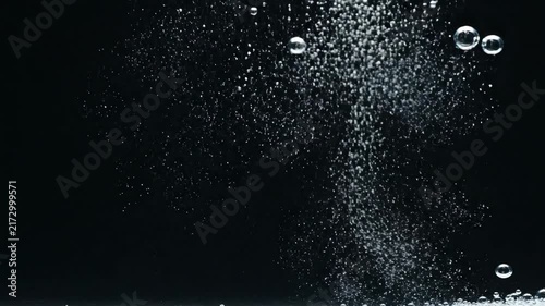 Bubbles ascend through dark liquid creates an abstract and serene scene