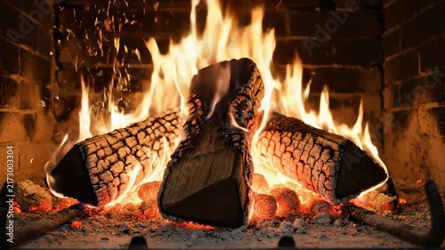 Burning fireplace logs with flames and brick background for home heating