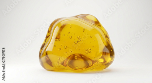Golden viscous liquid droplet with air bubbles isolated on white background. Macro of honey, oil serum or gel blob.