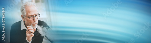 Foto Senior man smoking electronic cigarette; panoramic banner