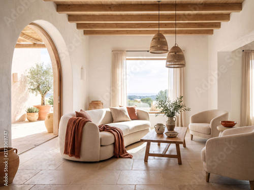 Elegant Mediterranean interior featuring beige sofa rustic wooden furniture natural textures arched windows ceramic pottery and sunlit neutral home decor