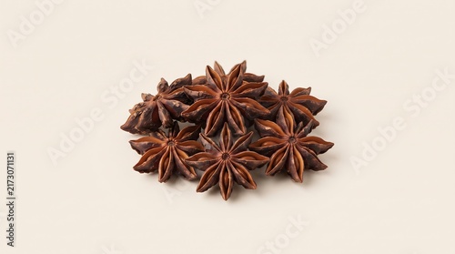 A small pile of dried star anise spice pods isolated on a light beige background