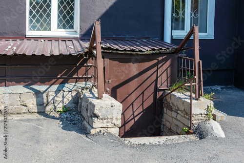 Basement entrance with metal bulkhead door on building exterior