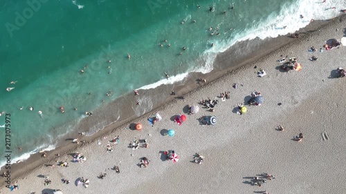 Aerial view of sunbathing people at the beach with colorful beach umbrellas	
