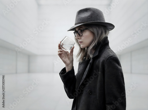 Cinematic portrait of a mysterious woman in a fedora and trench coat holding a glass of water