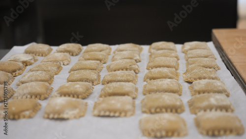 Obraz na płótnie Close up of freshly made pasta dough squares arranged neatly on parchment paper