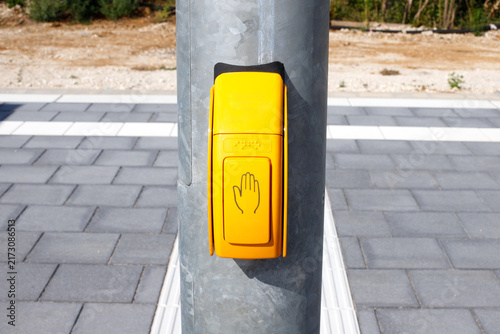Yellow Pedestrian Push Button Box with Hand Symbol on Metal Pole