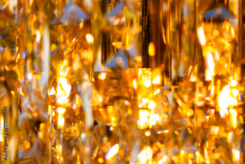 Macro close up of faceted golden crystal chandelier pattern texture background