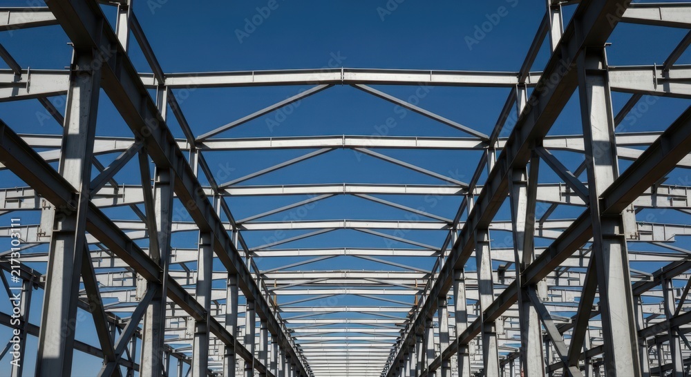 Obraz premium Industrial steel structure under blue sky: architecture and construction framework