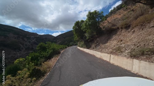 A car drives slowly along a dangerous winding mountain road on the island of Crete, Greece.