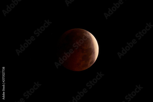 Blood Moon during a lunar eclipse in dark night sky