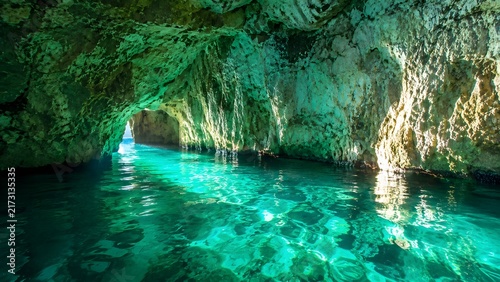Emerald Grotto cave with glowing crystal clear turquoise water and rock formations