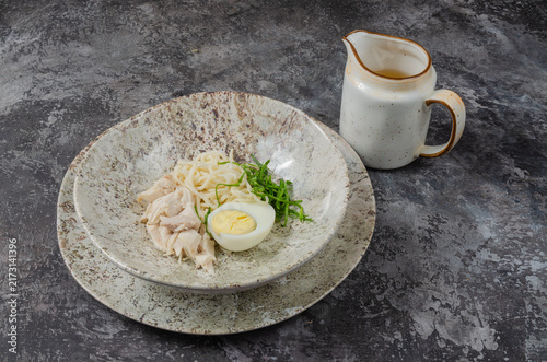 Foto Chicken Noodle Soup Ingredients with Hard-Boiled Egg and Broth Pitcher on Rustic