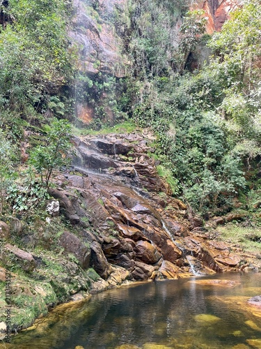 La Colina waterfall in Chiquitania region in Bolivia, surrounded by lush tropical vegetation and rugged natural scenery.