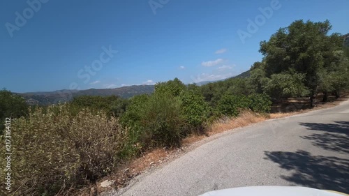 A car drives slowly along a dangerous winding mountain road on the island of Crete, Greece.