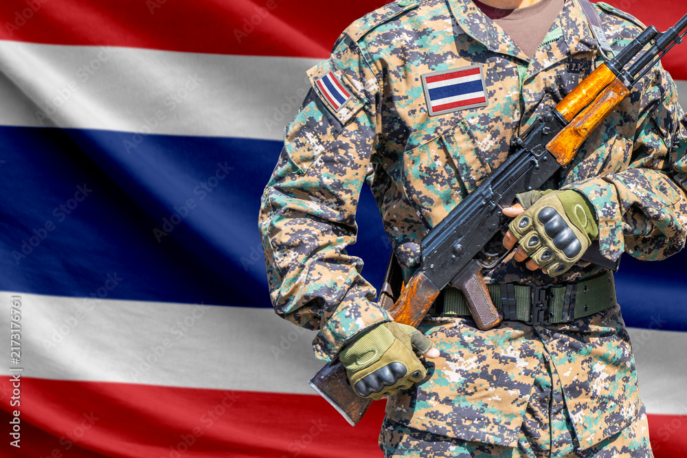 Naklejka premium Thailand flag with soldier holding assault rifle