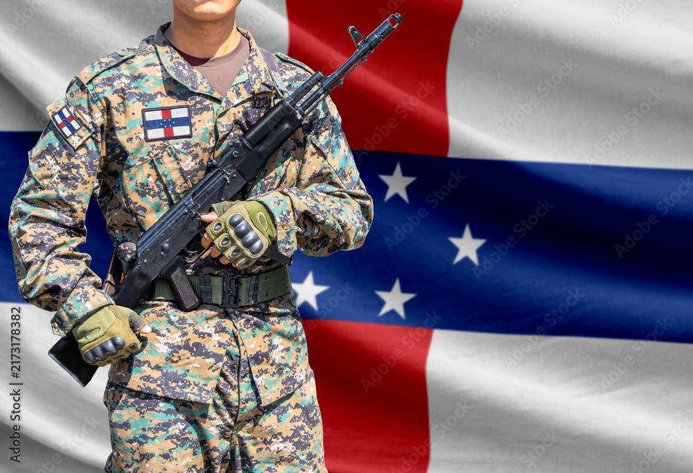 Naklejka premium Netherlands Antilles flag with soldier holding assault rifle