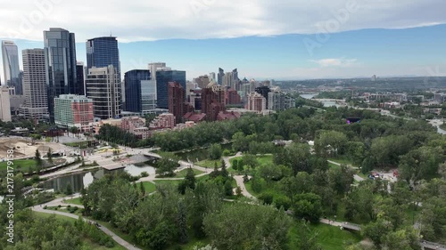 panning left along Skyline of Downtown Calgary ( Alberta, Canada)  to Centre St Bridge, with Prince’s Island Park and Bow River below and skyscrapers in front - 4k aerial video footage 