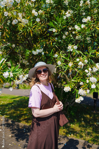 Portrait of Smiling Woman Under Blooming White Oleander Bush